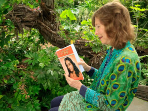 Woman Reading Autobiography of a Yogi by Paramahansa Yogananda in a garden